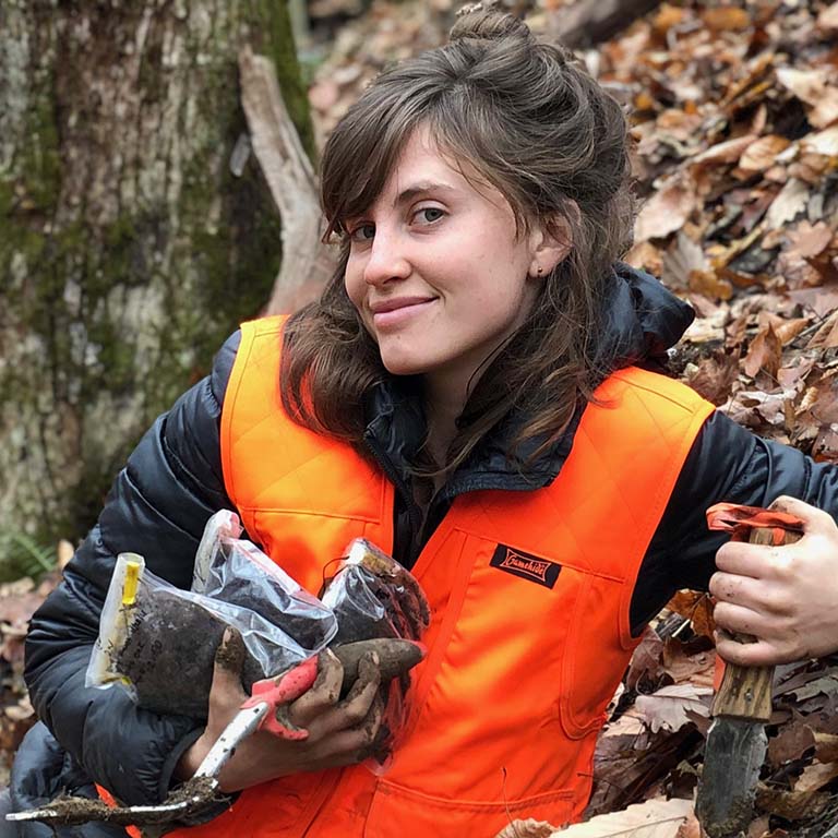 Katilyn Beidler collects soil samples from the forest.