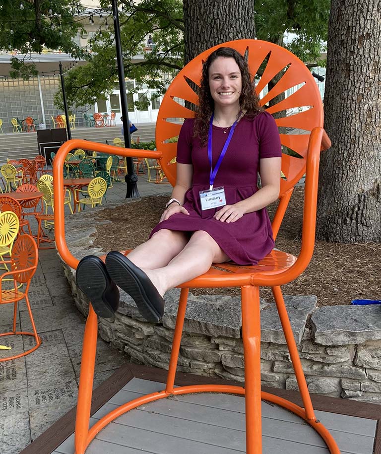 Lindsey Way sits in an oversized orange chair.