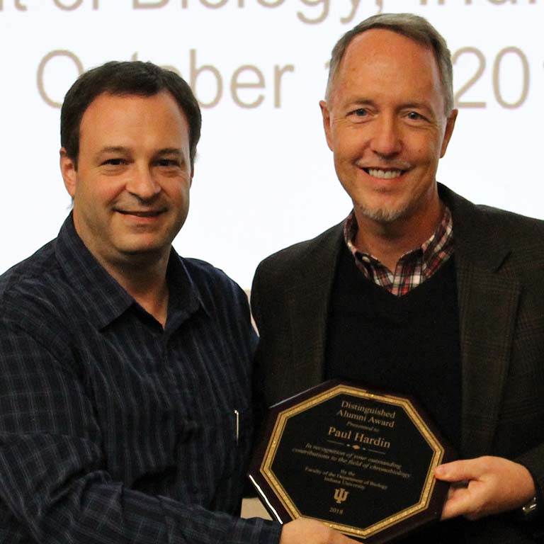 IU Biology Chair Greg Demas presents the Distinguished Alumni Award plaque to 2018 recipient Paul Hardin.