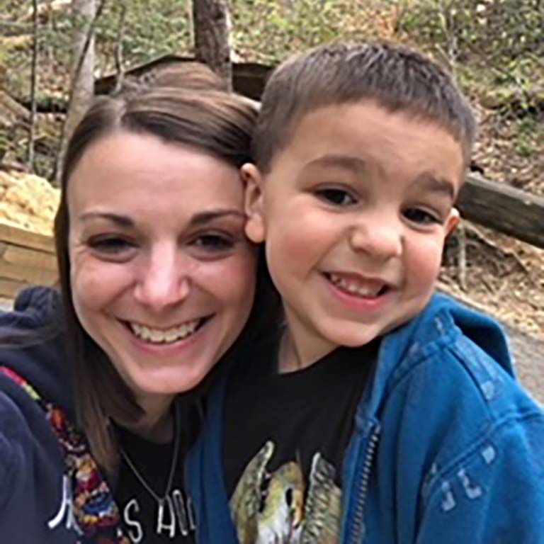 Cassie Orzech and her son Nolan pose together for a selfie in the woods.