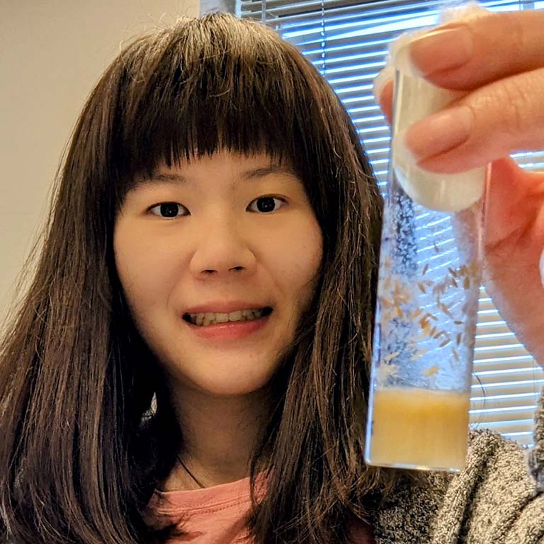 Yi-Ting Huang holds up a vial of fruit flies.