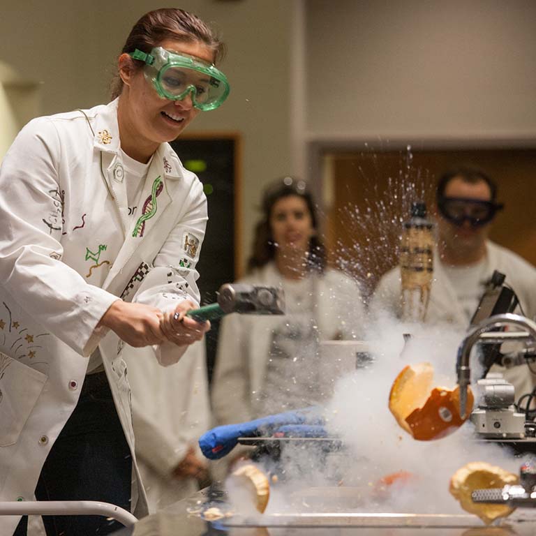 An instructor smashes a pumpkin frozen in liquid nitrogen during a demonstration at IU Science Fest.