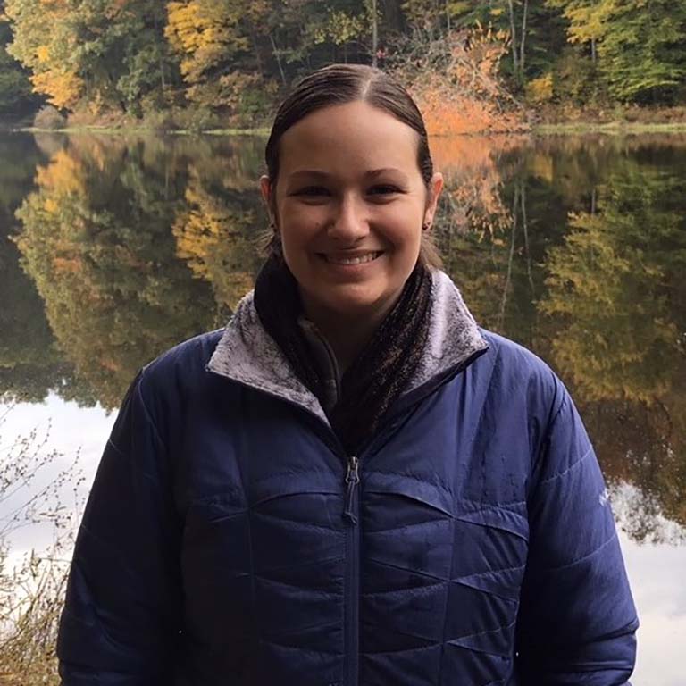 A lake and trees in autumn colors are the backdrop for this photo of Kat Munley.