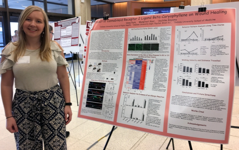 Anna Purk stands next to her research poster.