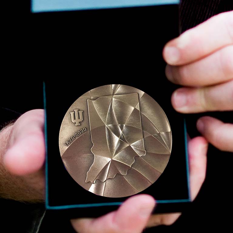 Craig Pikaard, recipient of the IU Bicentennial Medal, holds open the box to display the medallion.