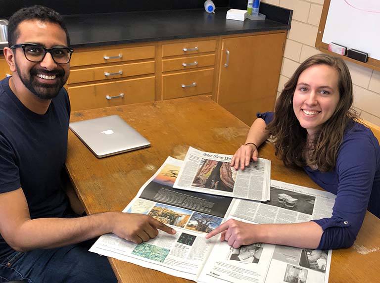 Ankur Dalia (left) and Courtney Ellison point to the New York Times article about their research discovery in 2018.