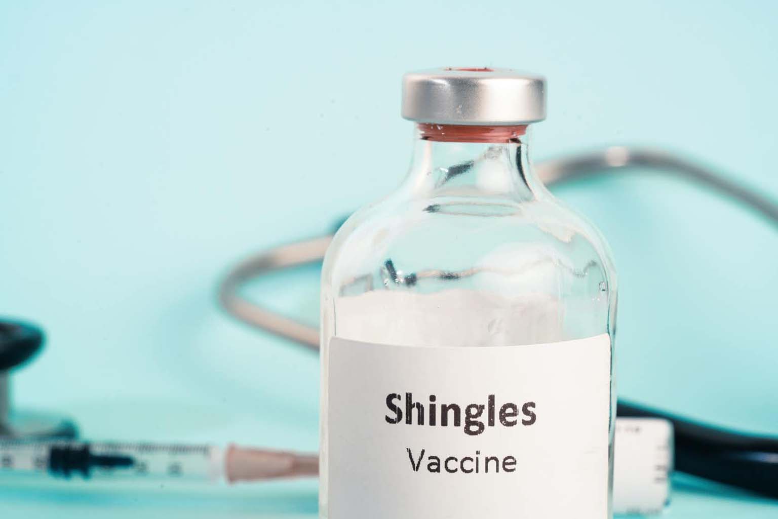 A bottle of shingles vaccine and a syringe.