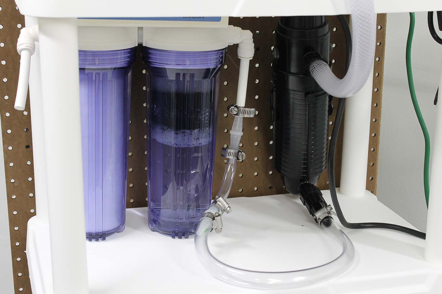 The three filtering containers connected to the 100-gallon tank that stores the artificial seawater for the coral tanks.