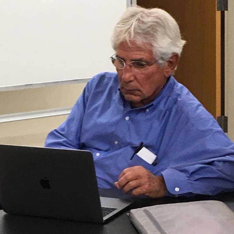 Mitchell Sogin sitting at a laptop as he works on manuscripts.