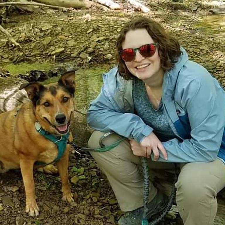 Megan Murphy with her dog Margo in the woods.