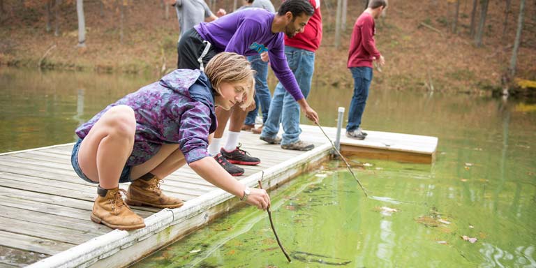 Students testing water with a stick